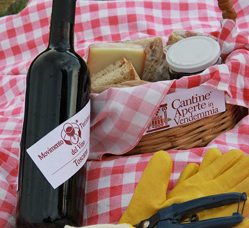 Bottiglia di vino e paniere con tante golosità