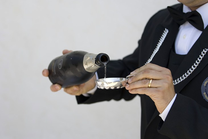 Un sommelier che versa il vino su un wine taster